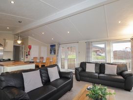 A living room with sofas and dining area at Monach 1