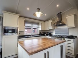 A kitchen with a wooden island and stainless steel appliances at Monach 1 in 