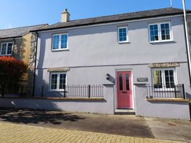 A house with a pink door and sign at Trelawney House in St. Austell