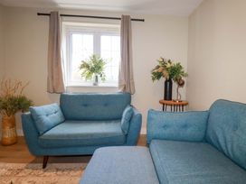A living room with a blue sofa and plant at 3 Rope Walk in St. Austell
