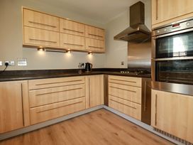 A kitchen with wooden cabinets and appliances at 3 Rope Walk in St. Austell
