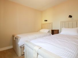 A bedroom with two beds and a nightstand at 3 Rope Walk in St. Austell