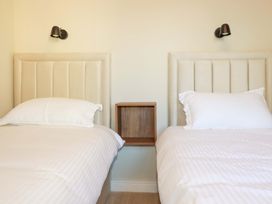 A bedroom with two beds and a nightstand at 3 Rope Walk in St. Austell