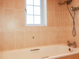 A bathroom with a bathtub and showerhead at 3 Rope Walk St. Austell