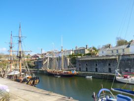A harbor with sailing ships and buildings at 3 Rope Walk in Duporth near Charlestown