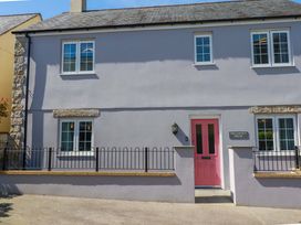 A house with a pink door and sign at Trelawney House Duporth near Charlestown