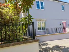 An outdoor view of a house with windows and a pink door at Trelawney House Duporth near Charlestown