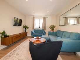 A living room with a sofa and television at Trelawney House in Duporth near Charlestown