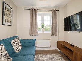 A living room with a sofa and television at Trelawney House in Duporth near Charlestown