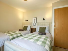 A bedroom with twin beds and a nightstand at Trelawney House in Duporth near Charlestown