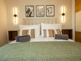 A bedroom with a bed and wall art at Trelawney House Duporth near Charlestown