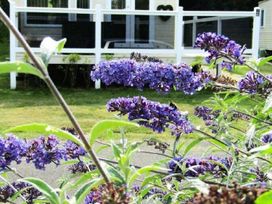 A garden with purple flowers and a deck at Seton Sands Caravan Park - Holiday Accommodation 13391 in Cockenzie And Port Seton