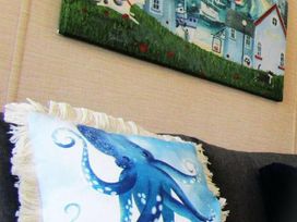A living room with a painting and a cushion featuring an octopus at Seton Sands Caravan Park - Holiday Accommodation 13391 Cockenzie And Port Seton