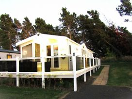 A caravan with a deck and pathway at Seton Sands Caravan Park - Holiday Accommodation 13391 in Cockenzie And Port Seton