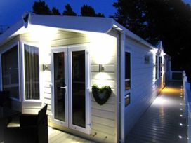 An exterior view of a house with lights on at Seton Sands Caravan Park - Holiday Accommodation 13391 Cockenzie And Port Seton