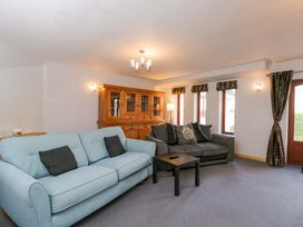 A living room with sofas and a dining cabinet at Lady Of Lourdes Whitchurch, Herefordshire