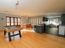A dining room with a pool table and kitchen area at Lady Of Lourdes in Whitchurch, Herefordshire