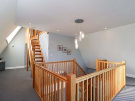 A hallway with staircase and framed pictures at Lady Of Lourdes in Whitchurch, Herefordshire