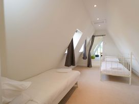 A bedroom with beds and windows at Lady Of Lourdes in Whitchurch, Herefordshire