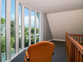 A landing with large windows and a chair at Lady Of Lourdes in Whitchurch, Herefordshire