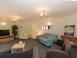 A living room with a sofa, television, and artwork at Lady Of Lourdes in Whitchurch, Herefordshire