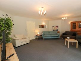 A living room with sofas, a coffee table, and a television at Lady Of Lourdes in Whitchurch, Herefordshire