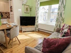 A living room with a tv and dining table at Rodwell Holt in Weymouth