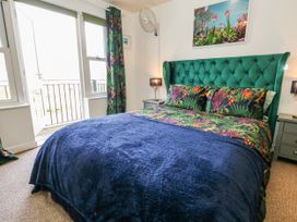 A bedroom with a green bed and lamps at Rodwell Holt in Weymouth