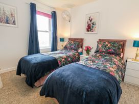 A bedroom with two single beds and a flower vase at Rodwell Holt in Weymouth