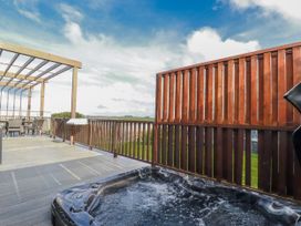 An outdoor deck with a hot tub and seating area at Adelaide in Redruth