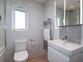 A bathroom with a toilet, wash basin, shower, and towel warmer at Adelaide in Redruth