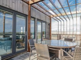 An outdoor area with a glass table and wicker chairs at Adelaide in Redruth