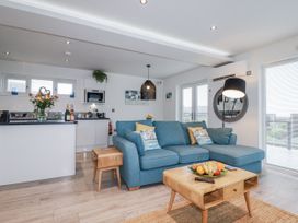 A living room with a blue sofa and a coffee table at Adelaide in Portreath