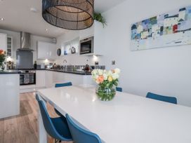 A kitchen with a dining table and flower vase at Adelaide in Portreath