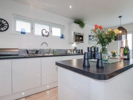A kitchen with flowers and utensils at Adelaide in Portreath