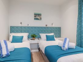 A bedroom with two beds and a plant at Adelaide in Portreath