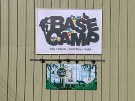 An outdoor sign for Base Camp offering climbing and café services