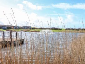 A lake with a dock and houses in the background at Adelaide in Portreath