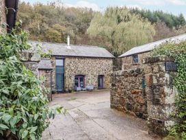 An outdoor area with stone buildings and seating at Clifford Lodge Barn in 