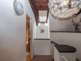 A hallway with a light fixture and painting at Clifford Lodge Barn