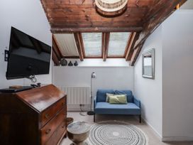 A cozy snug with a sofa and a television at Clifford Lodge Barn 