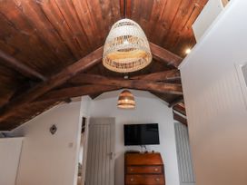 A bedroom with a wooden cabinet and TV at Clifford Lodge Barn 