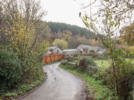 A view of a winding road with buildings and trees at Clifford Lodge Barn