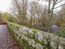 A stone wall covered in moss next to a stream at Clifford Lodge Barn
