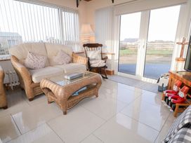 A conservatory with a sofa and coffee table at Storey and Half House in Annagry