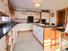 A kitchen with cabinets and an island at Storey and Half House in Annagry