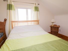 A bedroom with a bed and bedside table at Storey and Half House Annagry