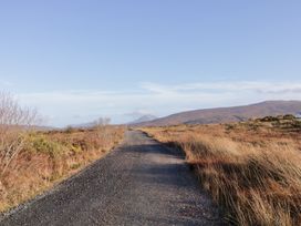 A gravel road leading to mountains at Storey and Half House in Annagry