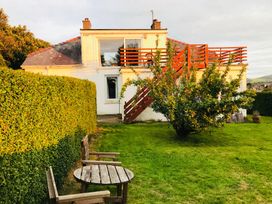 A house with a deck and stairs in the garden at Storey and Half House Near Annagry, County Donegal
