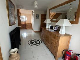 A hallway with a table and lamps at Storey and Half House Near Annagry, County Donegal